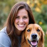 Emily, co-founder of PupGear Premium, posing with her Golden Retriever, Buddy